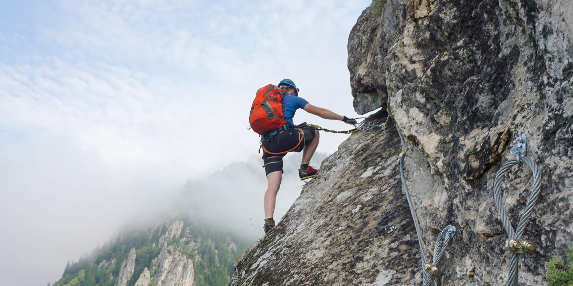 Student climbing a rock face